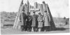 Unidentified Sousa Band members, standing in front of a historical Navajo hogan